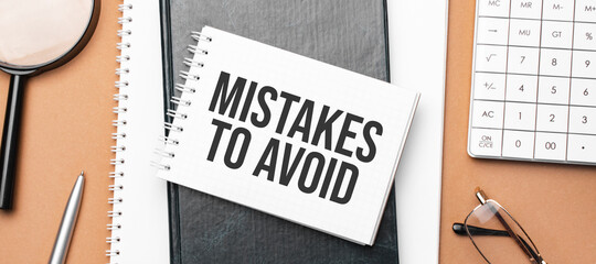 mistakes to avoid on notepad and various business papers on brown background. Brown glasses and...