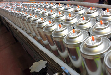 Manufacturing aerosol cans on factory conveyor