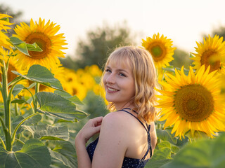 Mujer joven disfrutando de sus vacaciones de verano en un campo de girasoles