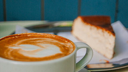 Great view of a coffee cup and a cheesecake in the background. It's a lovely design. a blue and blur background.