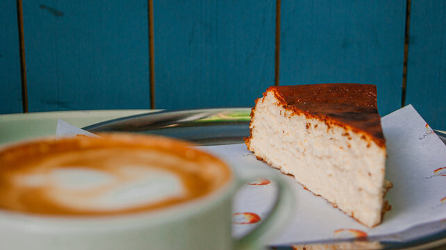 Great view of a coffee cup and a cheesecake in the background. It's a lovely design. a blue and blur background.