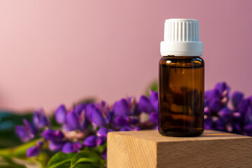 Bottle without label with oil on the stand. Transparent glass container with a dispenser on a beige-pink background. Product banner. Space for text, design.