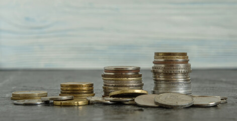 Coins from different countries are stacked in ascending order. In the foreground are also lying coins