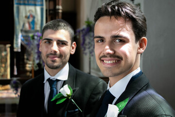 Smiling gay couple sitting and waiting in church to be married