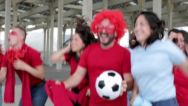 Excited multiracial people screaming and celebrating the victory of their team out of the stadium at the end of the match - Sports and entertainment concept