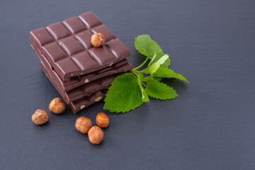 chocolate bars with hazelnuts, next to mint and hazelnuts