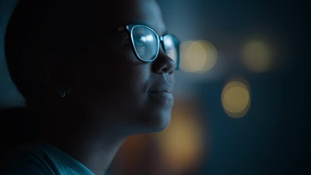 Portrait of a Teenage Multiethnic Black Girl Looking Out of the Window in Excitement. Surprised Young Female Watching the Night Sky from Her Home. She Wears Glasses and Dental Braces.