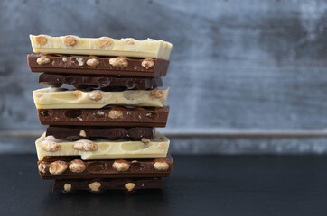 broken bars of black, white and milk chocolate with nuts