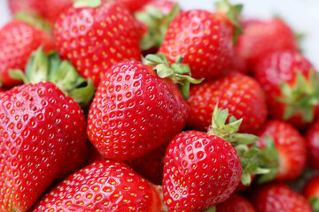 Fresh red strawberries with leaves. Pile of ripe strawberry for background