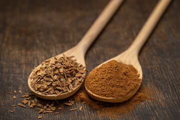 Natural cinnamon, ground in wooden spoons and sprinkled on a wooden table.