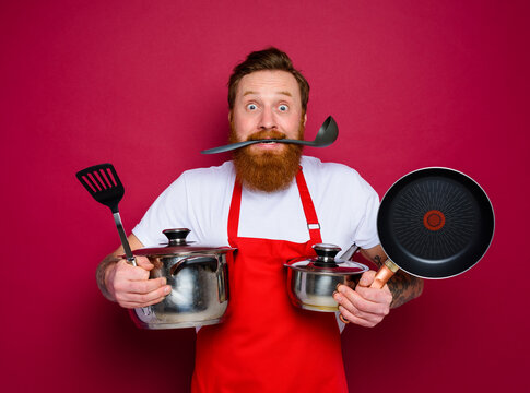 confused chef with beard and red apron is ready to cook