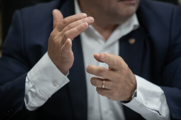 Businessman or politician giving inteview. Close up view gesticulating hands of business man.