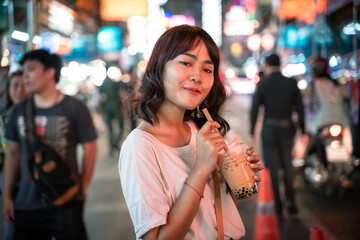 Portrait of Asian young woman with ice milk tea at Chaina town Yaowarat in bangkok, Thailand.