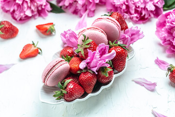 Elegant sweet macarons and Pink peony rose flowers, French delicate dessert on a white background. Long banner format. top view