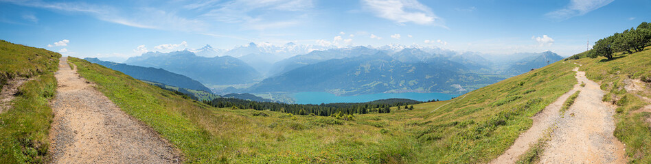 hiking trail at wide Niederhorn mountain ridge, with vew to swiss alps Bernese Oberland and lake Thunersee