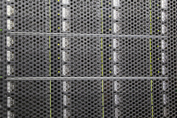 View through the grate to server rack in data center. Storage with SATA hard drives