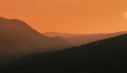 three-dimensional landscape shot with hills in the orange sunset