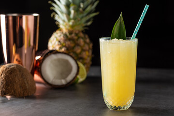 Cocktail with pineapple, coconut and lemon on stone background