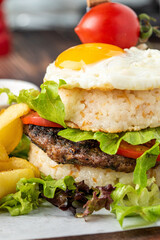 Korean burger with sunny side up egg, rice and fried fries on wooden background