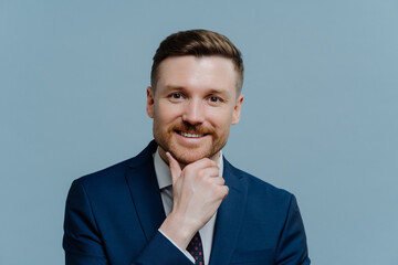 Headshot of successful happy businessman in suit looking at camera