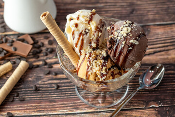 Chocolate, cream and caramel Roma ice cream in a glass bowl with hazelnut and chocolate sauce...