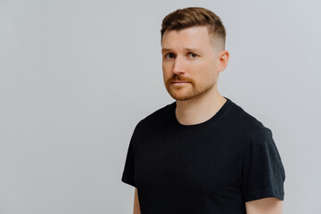 Young ginger man feeling sad and disappointed, looking at camera with frustrated face expression