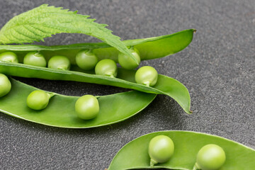 Opened pods of green peas on table