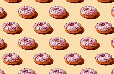 Pattern of pink donuts on yellow pastel background