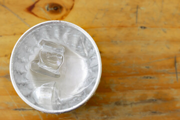 Ice and water in glass vintage on wooden table at restaurant. Blurred background.