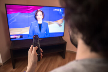 man watching tv and use remote controller