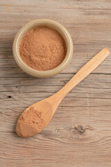 cinnamon powder in a bowl on the wooden table with copy space