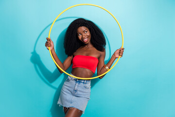 Photo of attractive cool afro american young woman look empty space hold circle isolated on teal color background © deagreez