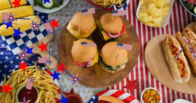 Animation of stars and american flags over table with different food
