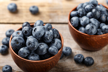 Freshly picked blueberries in clay bowl on wooden background. Concept of healthy and dieting eating. Tasty food.