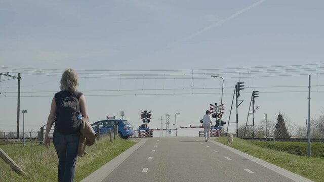 Woman walking near railroad crossing in Maatgravenweg