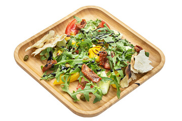 Vegetable salad. Salad with arugula and tomatoes in a wooden plate isolated on white background.
