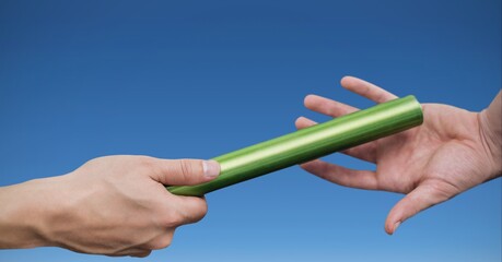 Composition of caucasian athletes passing green relay baton over blue background