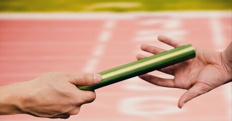 Composition of caucasian athletes passing green relay baton over racing track background