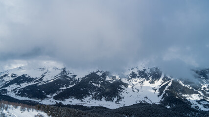 The image of the ski slopes covered by snow clouds.