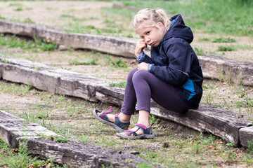 enfant fille boude dans son coin