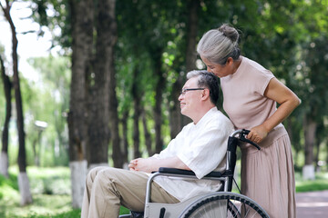 The old man pushes his wife in a wheelchair