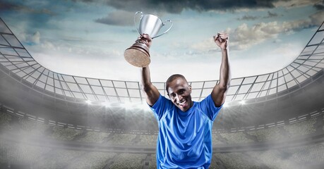 Fototapeta na wymiar Composition of sportsman celebrating victory, holding trophy at stadium
