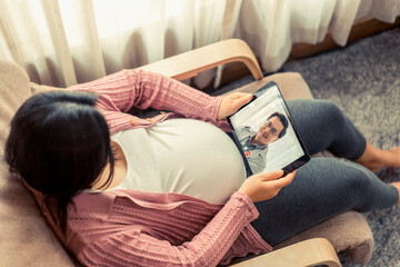 Doctor telemedicine service online video with pregnant woman for prenatal care . Remote doctor healthcare consultant from home using online mobile device connect to internet for live video call . - obrazy, fototapety, plakaty