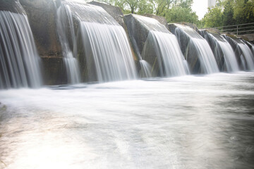 Fototapeta na wymiar Long exposure shot of a waterfall in a city park.