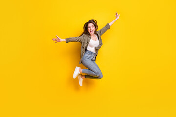 Full length body size view of attractive cheerful girl jumping having fun success isolated over bright yellow color background