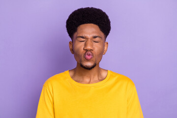 Portrait of attractive affectionate dreamy guy sending you air blow kiss pout lips isolated over violet purple color background