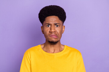 Portrait of attractive moody confused guy bad mood grimacing isolated over violet purple color...