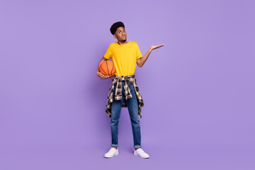 Full length body size view of attractive confused guy holding ball shrug shoulders isolated over violet purple color background