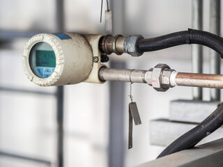 Temperature transmitter for measuring instrument close up in industry zone at power plant.