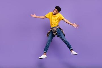 Full length body size view of attractive cheerful sly guy jumping having fun good mood isolated over violet purple color background